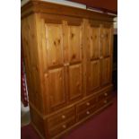 A modern pine four door wardrobe over six short lower drawers, width 187cm