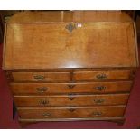 An early 19th century provincial oak slopefront writing bureau, having a fitted interior over two