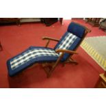 A contemporary teak slatted folding steamer chair with lower attachment
