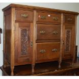 An Edwardian walnut sideboard fitted with five drawers and twin floral relief carved cupboard doors,