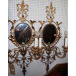 A pair of contemporary floral gilt decorated metal girandols, each with oval mirrorplates and twin