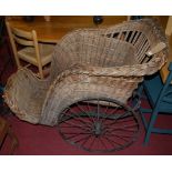 A 19th century black painted iron framed and wicker bath chair