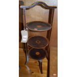 An early 20th century stained walnut three-tier cake stand, with painted decoration