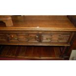 An early 20th century boarded and geometric moulded oak dresser base, of good size, having three