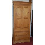 A modern pine double door wardrobe, having twin long lower drawers, w.91cm
