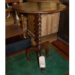 An early 20th century oak circular fixed top pedestal occasional table, having a barley twist