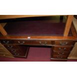 An Edwardian walnut and gilt tooled leather inset twin pedestal writing desk, having typical