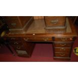 A circa 1900 mahogany and gilt tooled leather inset twin pedestal writing desk, having typical