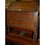 A 1920s moulded oak writing bureau raised on barley twist turned supports, width 75cm, together with