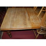 A late Victorian oak extending dining table, having a wind-out action and single drop-in leaf,