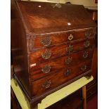 A George III mahogany and flame mahogany slopefront writing bureau, having a fitted interior over