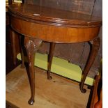 An early 20th century walnut and figured walnut demi-lune fold-over card table, having a baize lined