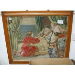 A large woolwork panel, depicting figures at a bedside, within a maple frame, 65 x 65cm