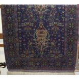 A Persian woollen blue ground rug, the central field decorated with vase of flowers, within