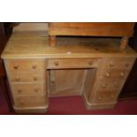 A Victorian pine ledgeback round cornered kneehole desk, having an arrangement of nine drawers and