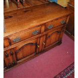 A large contemporary joined oak long sideboard, having four frieze drawers over conforming arch