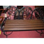 A black painted wrought iron and stained teak slatted three-seater garden bench, width 139cm