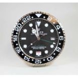 A wall clock, the dial in the form of a Rolex GMT Master Superlative chronometer, having sticker