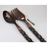 A novelty carved beech over sized fork and spoon, length 70cm