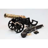 A Spanish model of a flintlock pistol, together with a model of an artillery cannon, having brass