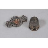 A late Victorian silver brooch, the yellow metal centre decorated with an urn issuing flowers;