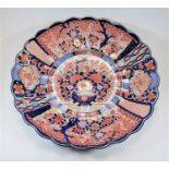 A large Japanese Imari charger of scalloped circular form, the centre decorated with basket