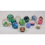 A collection of glass paperweights, together with a small Victorian green glass dump having flower