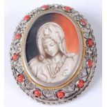 A continental white metal and coral set portrait brooch depicting religious portrait on ivory,