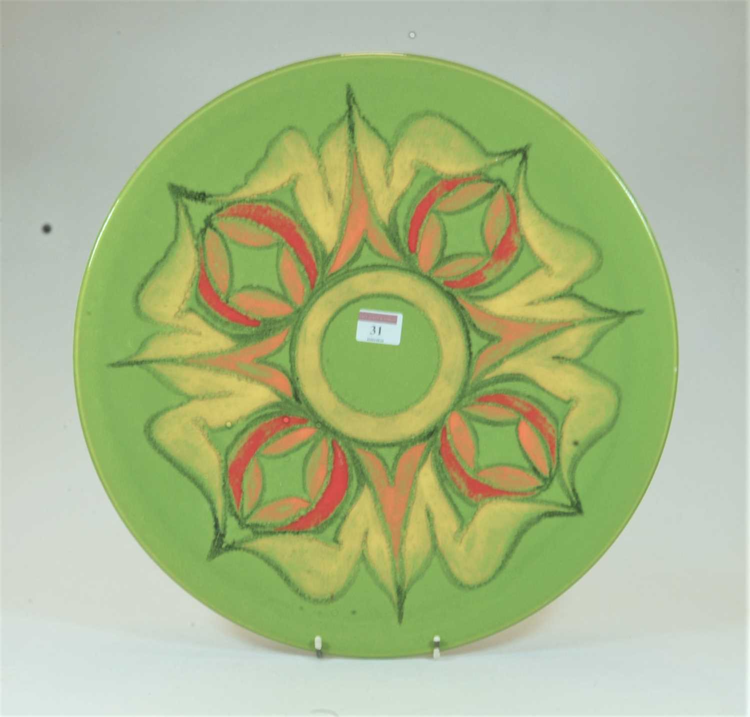 A large Poole Pottery Delphis charger on a green ground with red, orange and yellow floral