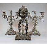 A late 19th century silver plate on brass clock garniture, the central clock having a convex