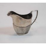 A silver cream jug of half reeded oval helmet form, 3.3oz, Sheffield 1909, maker James Deakin &
