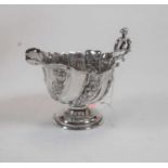 A late Victorian silver and embossed footed cream jug of helmet form, 2.7oz, Birmingham 1895, height
