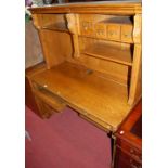 A contemporary oak desk, with open raised upper section; together with a nest of three oak