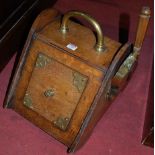 A Victorian oak and brass bound coal purdonium, having hinged compartment with shovel