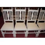 A set of four early 20th century and later cream painted oak slatback dining chairs, having