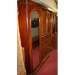 A Victorian mahogany gentleman's triple wardrobe, having end arch mirror doors with central