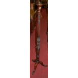 An early 20th century mahogany reeded, turned and floral carved standard lamp (lacking fittings),