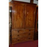 An early 19th century mahogany linen press, the twin upper doors enclosing fitted linen slides, over