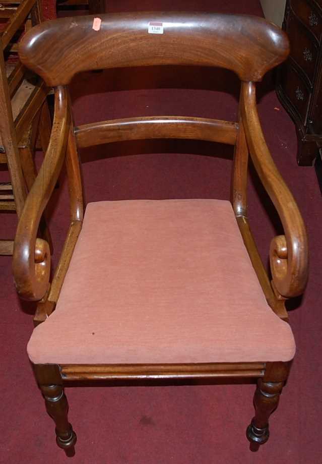 A Victorian mahogany barback scroll single elbow chair, having drop-in padseat and raised on