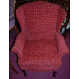 A contemporary red floral upholstered wingback armchair, raised on cabriole forelegs, w.79cm