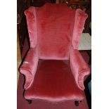 An early 20th century pink upholstered wingback scroll armchair, on cabriole forelegs, w.73cm