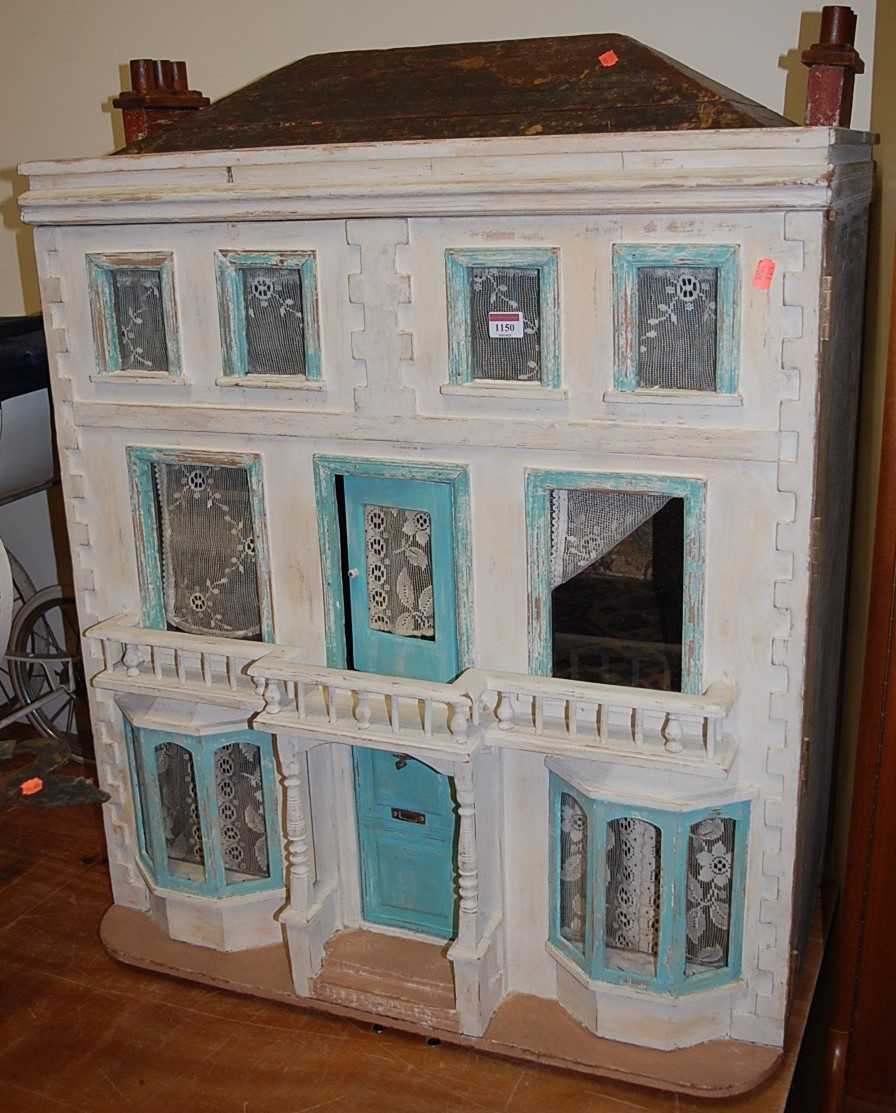 A painted three storey dolls house in the Georgian taste, having typical hinged opening, the