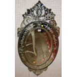 A contemporary Venetian bevelled and floral decorated oval wall mirror with sectional scroll outer