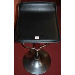 A pair of contemporary chromed metal and black vinyl seat pedestal bar stools, each with rise and