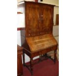 A 19th century Continental flame mahogany bureau cabinet, having twin upper doors over shaped fitted
