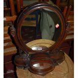 A mid-Victorian mahogany oval swing dressing mirror, having hinged compartment