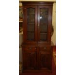 An Edwardian walnut bookcase cupboard having twin glazed upper doors, height 199cmCondition