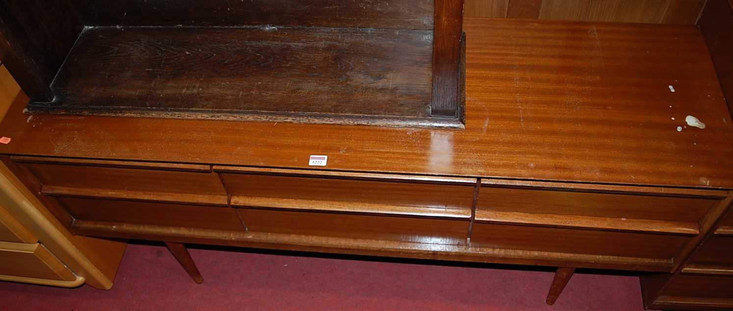 A 1970s teak low sideboard, fitted with four short drawers, raised on turned tapering supports, w.