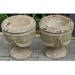 A pair of reconstituted stone circular pedestal garden urns (some losses and damage), dia.