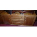 An Ercol light elm sideboard, having three central drawers flanked by conforming cupboard doors,